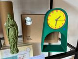 a clock that is sitting on a shelf next to a statue