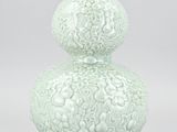 a white vase with a decorative design on it