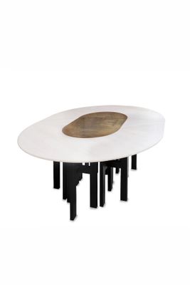 une table blanche aux pieds noirs, sur laquelle est posé un saladier en bois