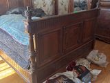 a bed that has a bunch of bags on the floor