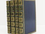 a set of five books with gold trimming and blue covers