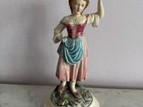 a figurine of a woman holding a basket on her head