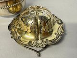 a silver bowl and a silver plate on a table