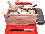 un étui rouge contenant un stylo et d'autres objets