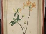 tableau représentant des fleurs jaunes, encadré dans un cadre en bois et posé sur une table