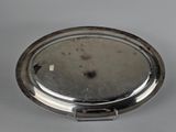 an image of a silver plate with a handle on a gray surface