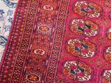 an oriental rug on a wooden floor with a cat laying on top of it