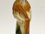 figurine représentant un homme vêtu d'une robe verte et jaune