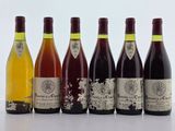 six bouteilles de vin sont alignées sur une table