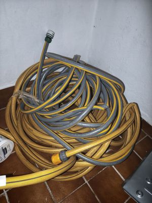 yellow and gray hoses are on the floor next to a white wall