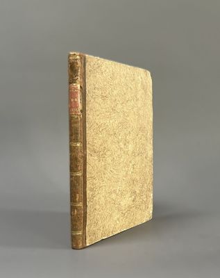 an old book sitting on top of a table with a gray background