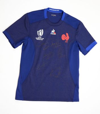 the shirt is blue and has a red rooster on it