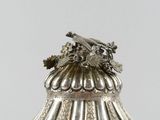 an antique silver plate with a bird on top of it