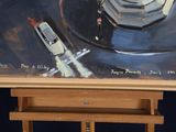 a painting on a easel with a painting of a city