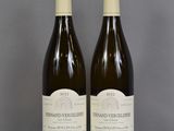 two bottles of wine sitting on top of a table next to each other