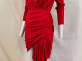 une robe rouge posée sur un présentoir à mannequin, sur fond blanc