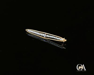 une barrette en or et diamants posée sur un fond noir
