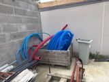 un tas de tuyaux posés par terre à côté d'un bâtiment