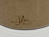 a brown vase with writing on it on a table