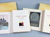 trois livres sont ouverts sur une surface bleue, sur fond bleu