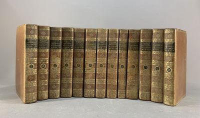 six vieux livres sont alignés sur une surface blanche
