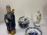trois figurines et un bol posés sur une table