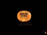 une pierre de quartz jaune sur une surface noire