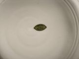 a close up of a white bowl with a green label on it