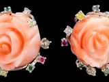 paire de boucles d'oreilles en forme de roses roses, ornées de pierres multicolores sur fond noir