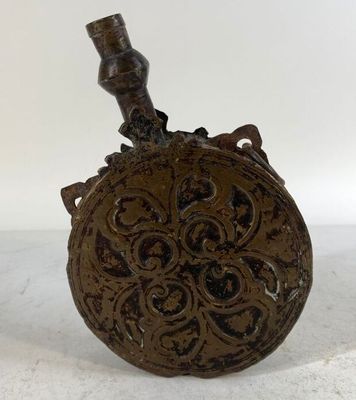 flasque antique en fonte avec un oiseau sur le dessus