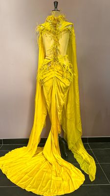 a yellow dress on a mannequin stand in a room