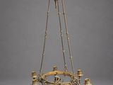 a brass chandelier with four candles and a bird on the top