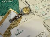 une montre Rolex posée sur une pile de papiers