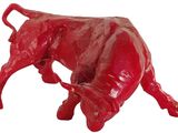 une statue rouge représentant un taureau sur fond blanc