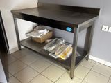 a metal table with a bunch of bags of food on it
