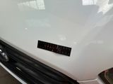 a close up of a white car with a sticker on it