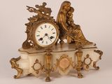 a gold clock sitting on top of a marble table