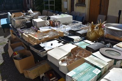 many boxes of items on a table outside of a house