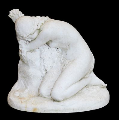 une statue blanche représentant une femme assise sur un rocher