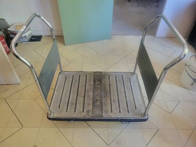 un tabouret métallique posé par terre dans une pièce