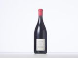 a bottle of red wine sitting on top of a white table