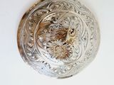 a close up of a silver plate with a bird on it