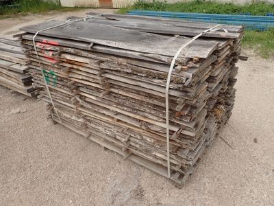 plusieurs morceaux de bois empilés les uns sur les autres dans une cour