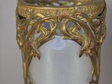 a gold vase with a white glass inside of it