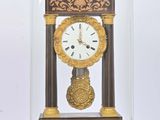une petite horloge sous un dôme de verre sur une table