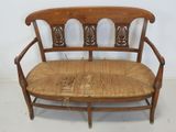 a wooden bench with a woven seat on it