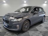 the front end of a grey bmw x1 parked on a checkered floor