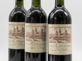 three bottles of red wine sitting next to each other on a white surface