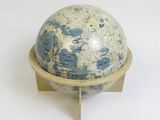 a small blue and white globe on a wooden stand