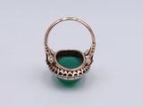 a close up of a ring with a green stone inside of it